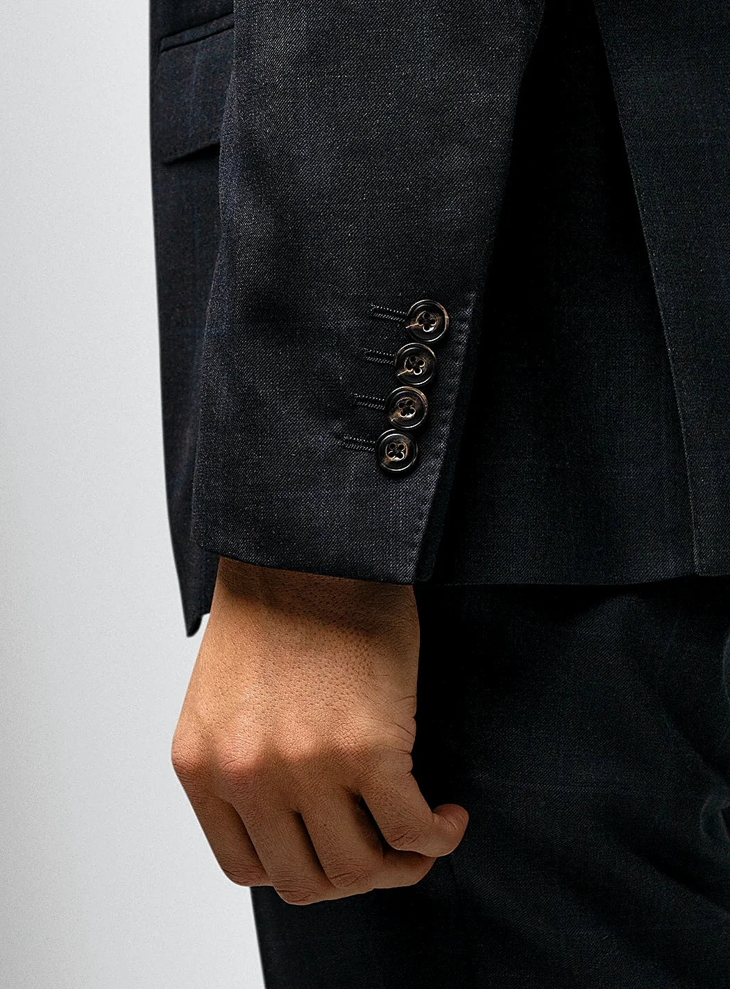Lapel and flap pocket detail of the checked jacket