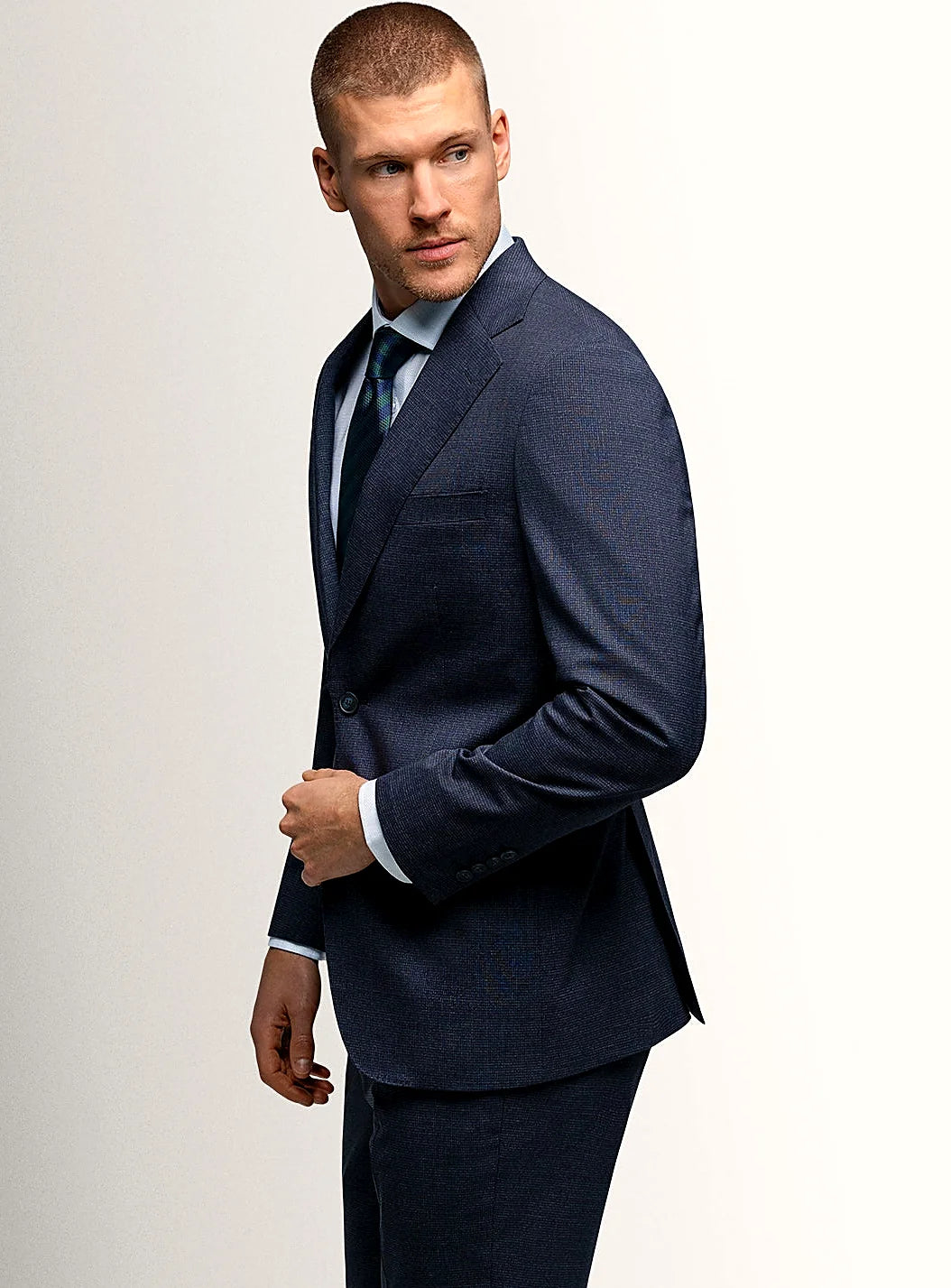 Notch lapel and flap pocket detail of the navy jacket