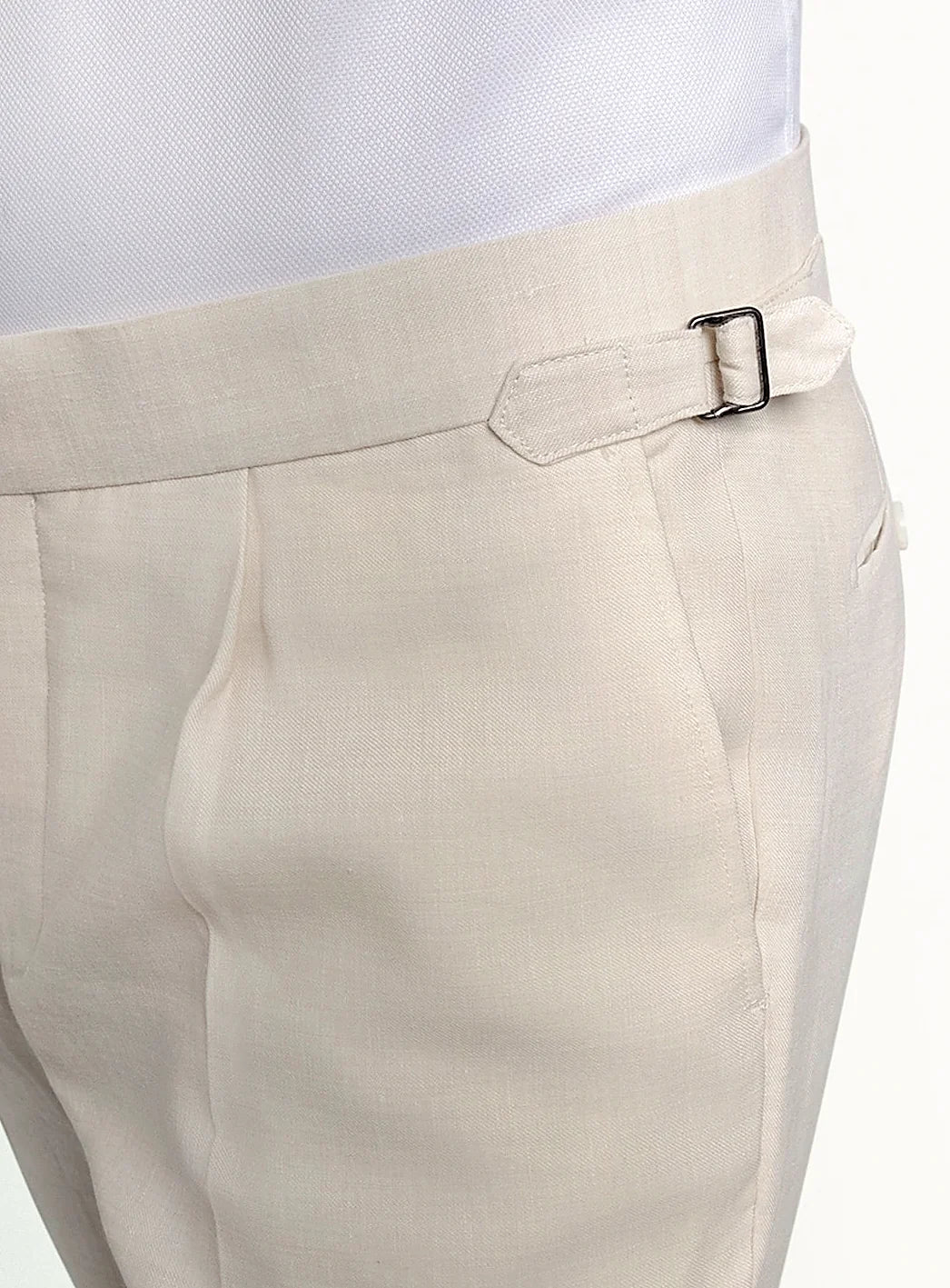 Waistband and front detail of the cream trousers