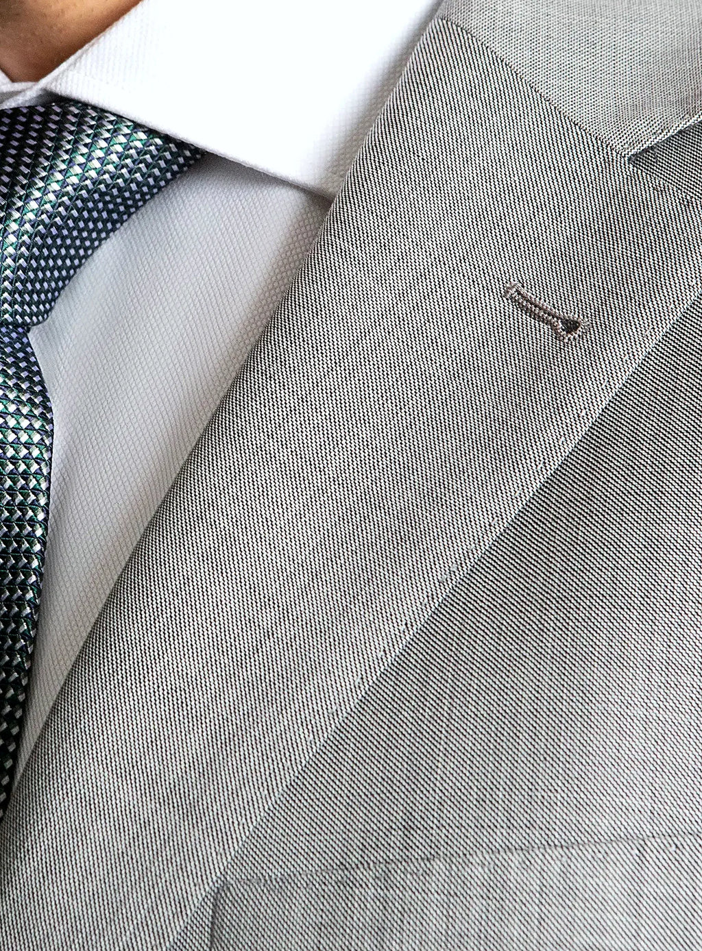 Lapel and chest pocket detail of the grey jacket
