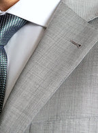 Lapel and chest pocket detail of the grey jacket
