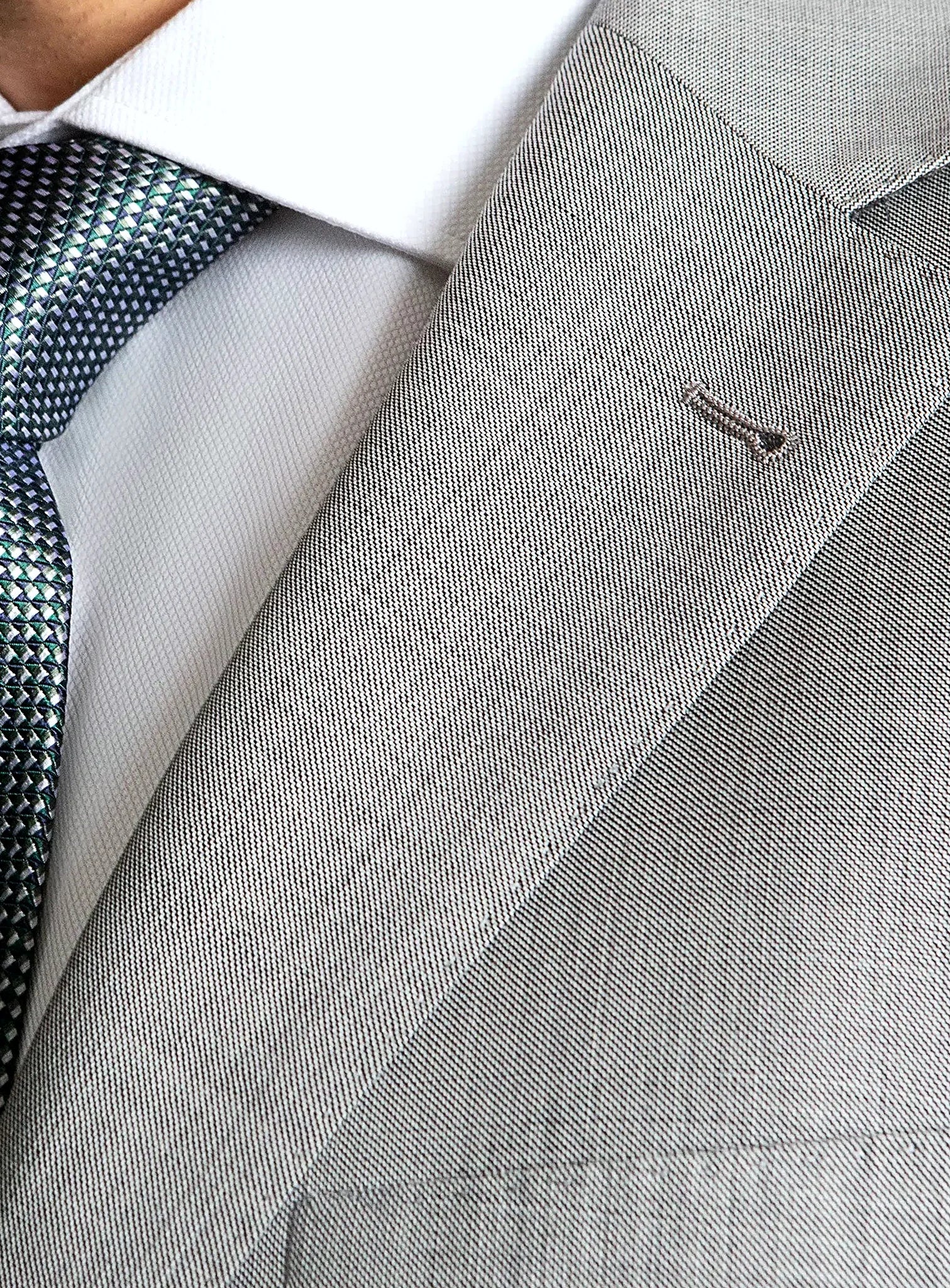 Lapel and chest pocket detail of the grey jacket
