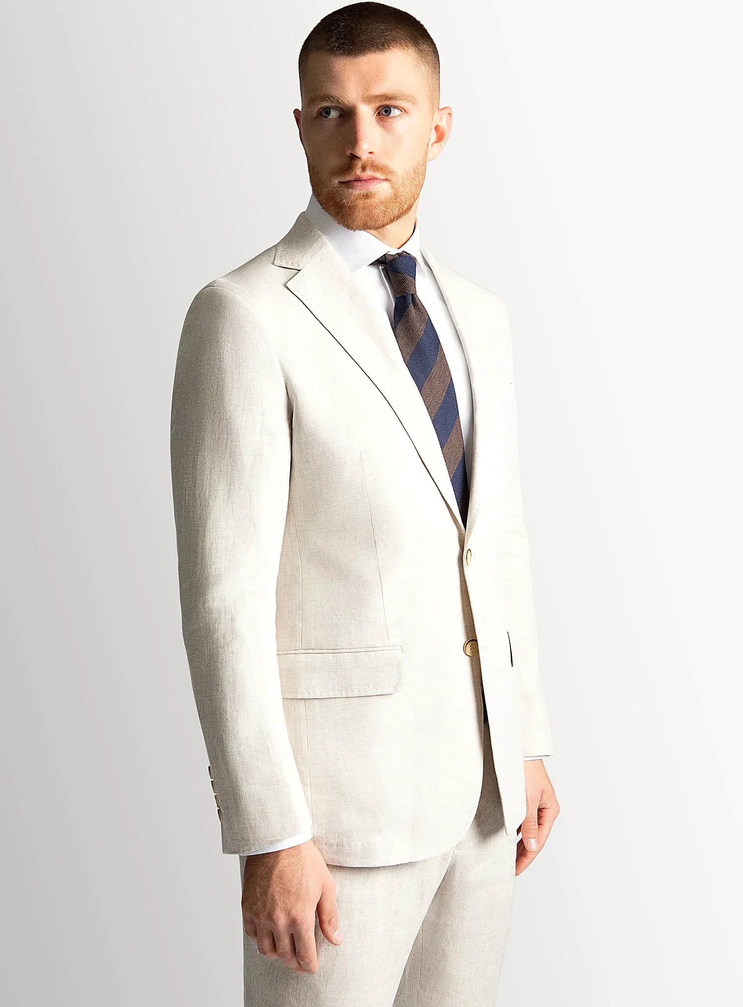 Sand linen blazer worn open over a pale shirt