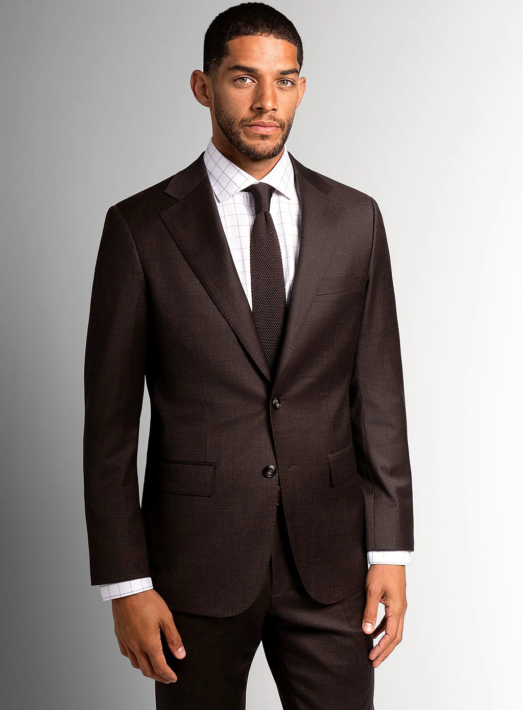 Lapel and buttoning detail of the brown suit jacket