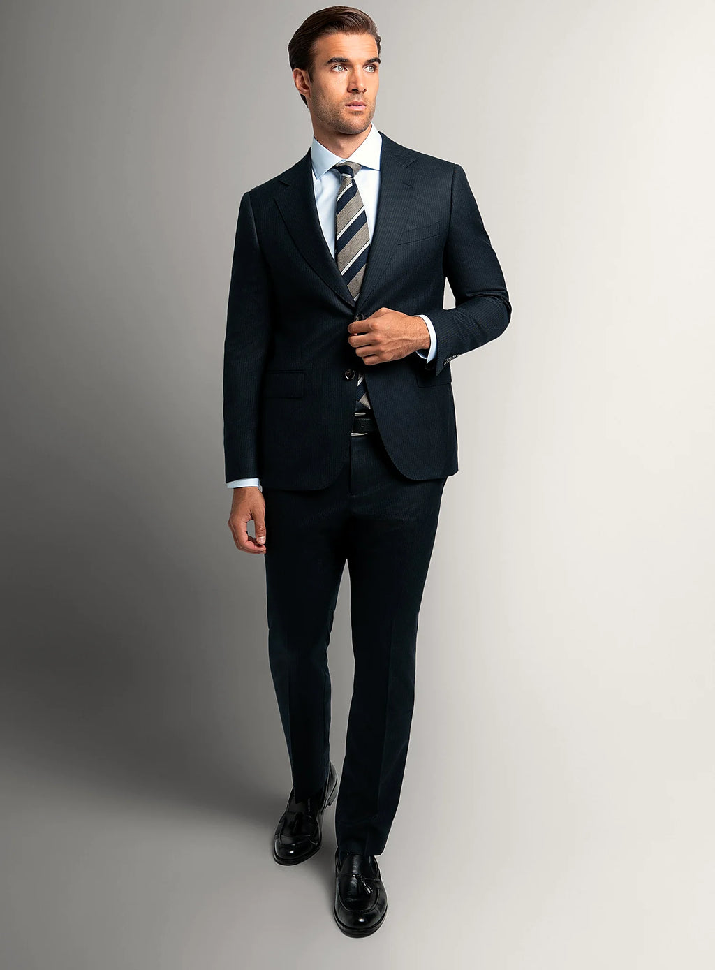 Angled view of the navy jacket and matching trousers