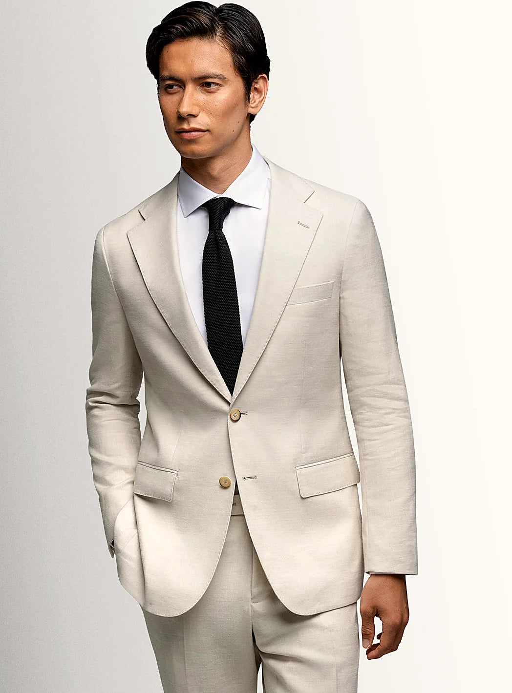 Cream sports jacket worn open over a pale shirt