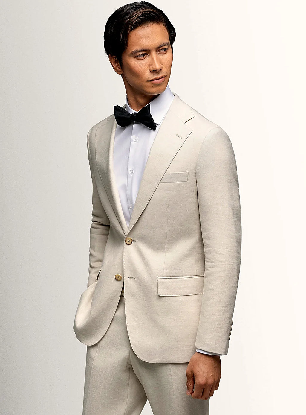 Notch lapel and flap pocket detail of the cream jacket